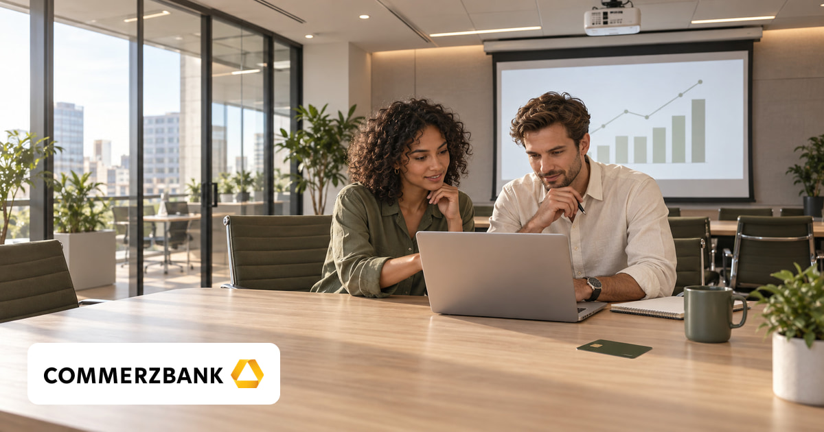 Ein Mann und eine Frau gemeinsam am Laptop im Büro, eine Kreditkarte auf dem Tisch und das Logo von Commerzbank unten links.