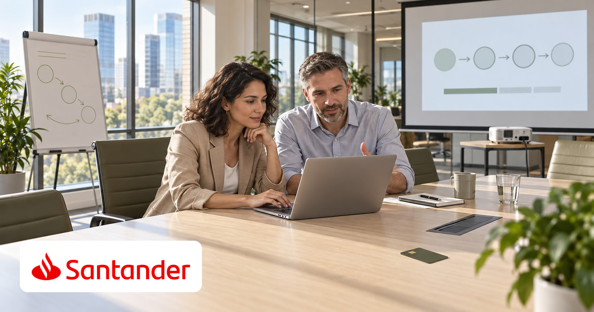 Ein Mann und eine Frau gemeinsam am Laptop im Büro, eine Kreditkarte auf dem Tisch und das Logo von Santander unten links.